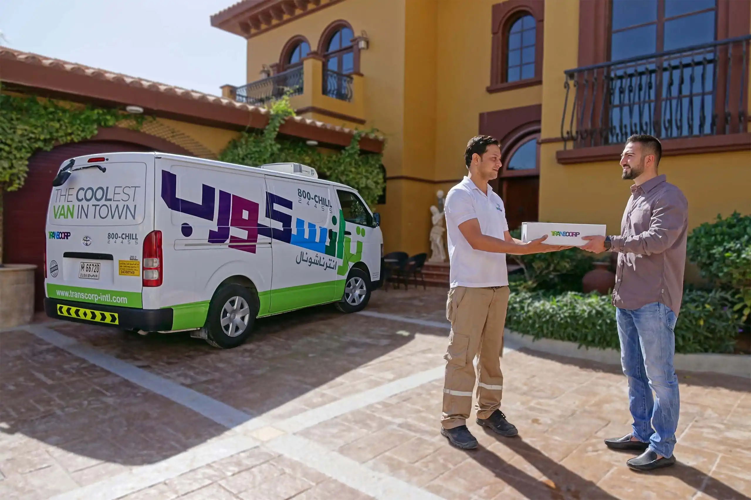 Transcorp driver handing out the temperature controlled package with the delivery van in the background in Dubai